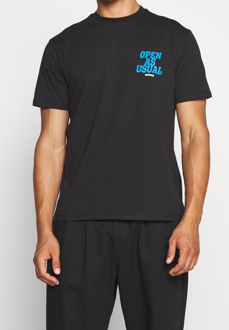Svart bomullströja med grafiken "ÖPPET SOM VANLIGT" i blått på bröstet. Kortärmad och med rund halsdesign, avslappnad passform.