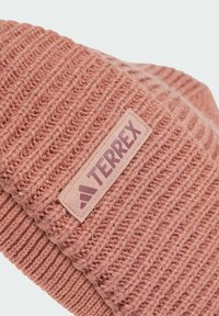 Knitted pink beanie featuring ribbed texture and a prominent rectangular label with "TERREX" branding in darker pink.