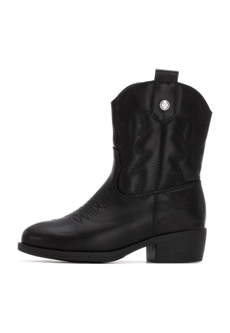 Bota de vaquero de cuero negro con un tacón bajo y cuadrado, costuras en zigzag en el eje y una tira de agarre en la parte trasera. Acentos de herrajes plateados.