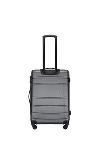 Hard-shell carry-on suitcase in matte gray, featuring horizontal grooves, extendable black handle, and four swivel wheels for easy maneuverability.