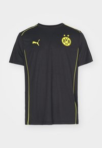 Černé sportovní tričko s žlutými lemy, logo Puma na pravé straně hrudi a odznak Borussie Dortmund BVB 09 na levé straně hrudi.
