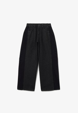 Zwarte denim broek met wijde pijpen en contrasterende donkere zijkanten. Met een traditionele knoopsluiting en vijf-pocket ontwerp.