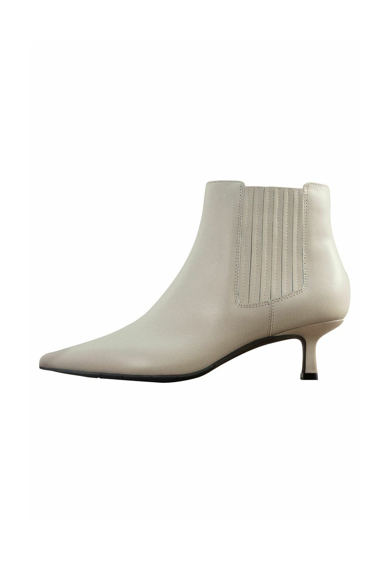 Bottine à talon aiguille en cuir beige lisse. Présente des côtes verticales sur le côté et un talon fin. Design minimaliste.