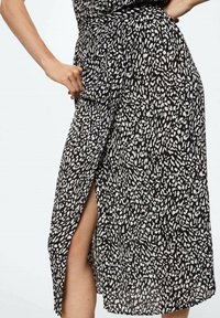 Černobílá tištěná zavinovací sukně s bočním rozparem, vyrobená z lehkého materiálu, s texturovaným vzorem a výrazným pasem.