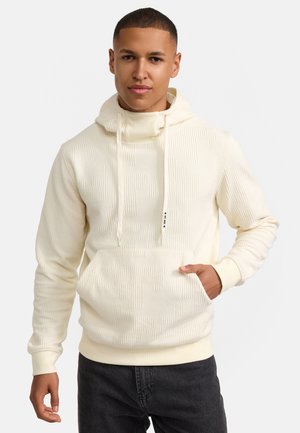 Creme hoodie med tekstureret mønster, snøre i hætten og forlomme. Har ribbede manchetter og kant, parret med mørke jeans.