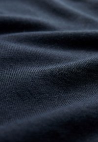Dark blue ribbed fabric with soft folds and visible knit texture, shown in close-up view.