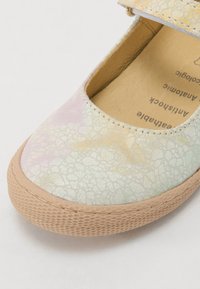 Scarpa stile Mary Jane con tomaia in pelle screpolata pastello, punta tondeggiante e suola in gomma testurizzata marrone chiaro con cinturino sicuro.
