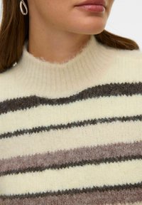 Suéter de punto con cuello acanalado en color crema y rayas horizontales en marrón y beige. La tela parece suave y con textura.