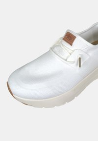 Scarpa bianca slip-on realizzata in materiale mesh testurizzato con colletto imbottito, dotata di una patch con logo color nocciola e suola in gomma.