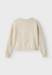 Pull court de couleur beige clair avec une texture tricotée douce, un col rond et des manches longues légèrement bouffantes. Aucun système de fermeture visible.
