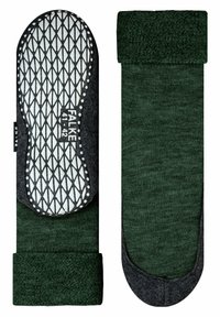 Calze verdi scure con texture, con risvolto e suola in gomma grigia caratterizzata da un motivo a rombi per una maggiore aderenza. Etichetta del marchio visibile.