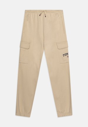 Pantaloni cargo beige con cintura elastica, cordoncino, tasche laterali e logo ricamato "TOMMY". Tessuto morbido, polsini a gamba affusolata.
