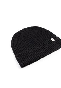 Black knitted beanie, featuring a ribbed texture and a folded cuff. Includes a small branded tag on the side for identification.