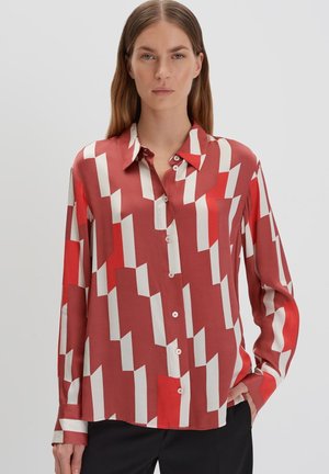 Camicia a maniche lunghe rossa e bianca con motivo, colletto, chiusura frontale con bottoni e texture liscia simile alla seta. Presenta forme geometriche.