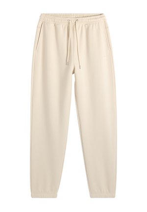 Pantalones deportivos beige con corte entallado, cintura elástica, cordón, bolsillos laterales y puños elásticos, diseñados para uso casual.