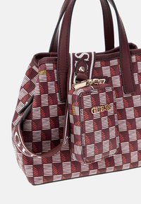 Rood-witte handtas met een patroon van synthetisch materiaal, dubbele handvatten, een afneembare pouch en gouden logoaccenten. Rechthoekige vorm met gestructureerde zijden.