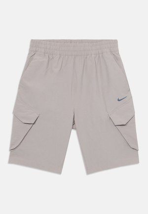 Shorts gris clair avec une ceinture élastique, des poches cargo latérales et un petit logo Nike bleu sur le devant. Tissu lisse et résistant.