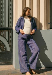 Lila Tweed-Jacke und -Hosen-Set mit strukturiertem Finish, weitem Bein, Knopfschluss und kombiniert mit einem gerippten weißen Top.