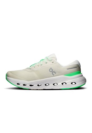 White athletic sneaker with green accents, lace-up closure, perforated mesh upper, thick sole with black oval cutouts, side logo visible.