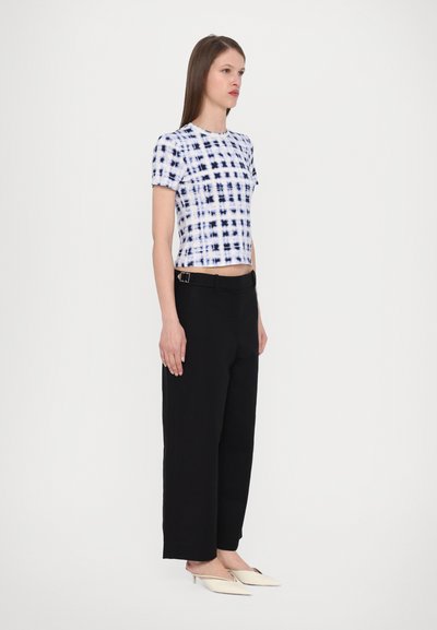 Cotton crop top with blue and black plaid pattern, paired with black wide-leg trousers and white pointed-toe shoes. Simple design and fit.