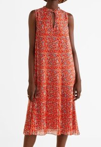 Robe florale rouge avec un décolleté en trou de serrure, sans manches, et une texture plissée. Le motif présente des nuances de rouge, bleu et blanc.