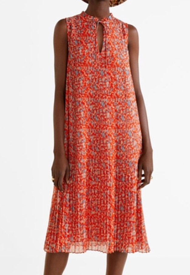 Robe florale rouge avec un décolleté en trou de serrure, sans manches, et une texture plissée. Le motif présente des nuances de rouge, bleu et blanc.