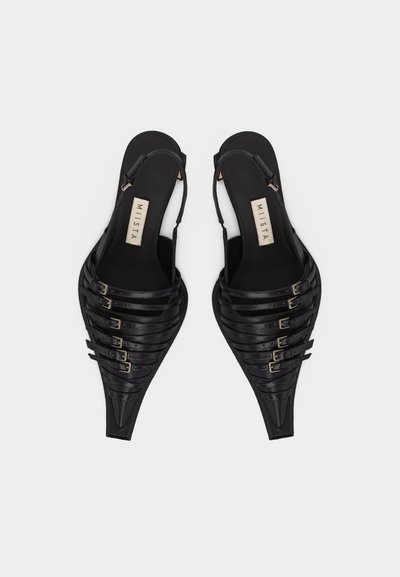 Μαύρα slingback φλατ παπούτσια με μυτερή μύτη και πολλαπλές λεπτές λουρίδες με αγκράφες μπροστά, με ετικέτα που δείχνει «MIISTA» στο εσωτερικό.