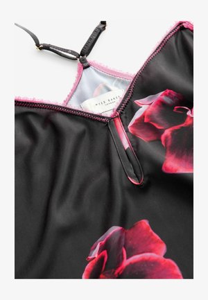 Musta mekko, jossa on punaisia kukkakuosisia kuvioita, säädettävät mustat olkaimet ja vaaleanpunainen skorenihelma kaula-aukossa ja kädenteissä.