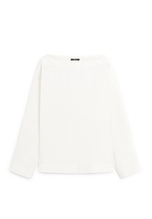 Bílý top s dlouhým rukávem a lodním výstřihem s jednoduchým, čistým designem a malou černou štítkem na límci.