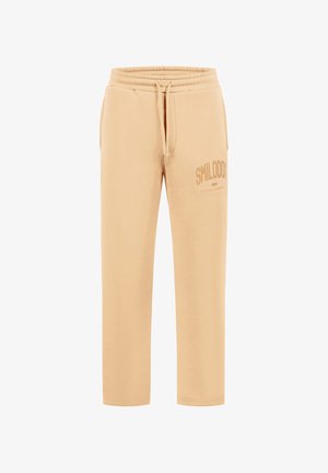 Beige taps toelopende joggingbroek met elastische tailleband, trekkoord, zijzakken en tekst "SMILODON" gedrukt op het bovenste linker dijbeen.