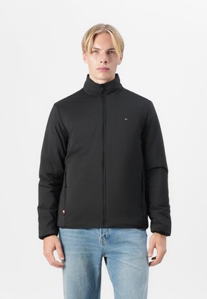 Zwarte zip-up jack met hoge kraag, voorzien van zijzakken en een klein logo op de linkerkant van de borst. Gladde textuur, lichtgewicht ontwerp.