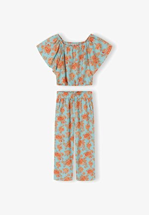 Ensemble deux pièces bleu clair à motif floral avec un haut court épaules dénudées et un pantalon ample taille haute ornés de motifs de fleurs orange.