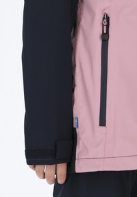 Pink and navy waterproof jacket with a zippered pocket, adjustable wrist cuffs, and a small flag accent on the side seam.