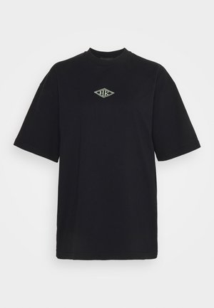 Czarny t-shirt z krótkim rękawem z małym białym logo w kształcie diamentu umieszczonym na środku klatki piersiowej.