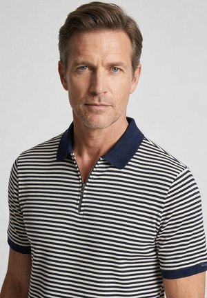 Middelbare man met lichte stoppels die een navyblauw-wit gestreept polohemd met korte mouwen draagt met een rits en een navyblauwe kraag.