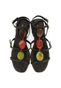 Sandalias planas negras con múltiples correas y un cierre en el tobillo. En el centro presenta piedras decorativas coloridas: ámbar, rojo, verde y a rayas.