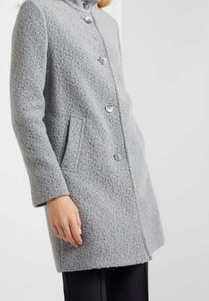 Grått texturerat ullkappa med stora knappar, krage och sidofickor, med rak skärning och långa ärmar.
