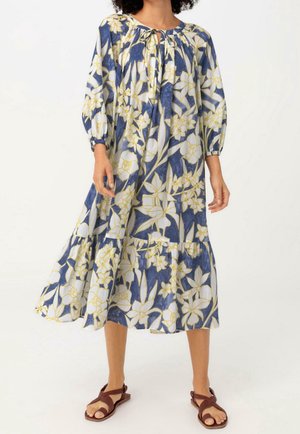 Vestido maxi floral con patrones de flores amarillas y azules, mangas largas, cuello fruncido y diseño de falda en capas. Tela ligera.
