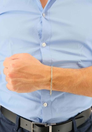 Silberne Armband mit einer strukturierten Oberfläche. Am Handgelenk getragen, im Kontrast zu einem hellblauen Hemd. Einfaches, elegantes Design, leichter Eindruck.