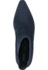 Stivaletto blu navy con punta affusolata, realizzato in materiale scamosciato, caratterizzato da una superficie liscia e dettagli di cucitura minimali.