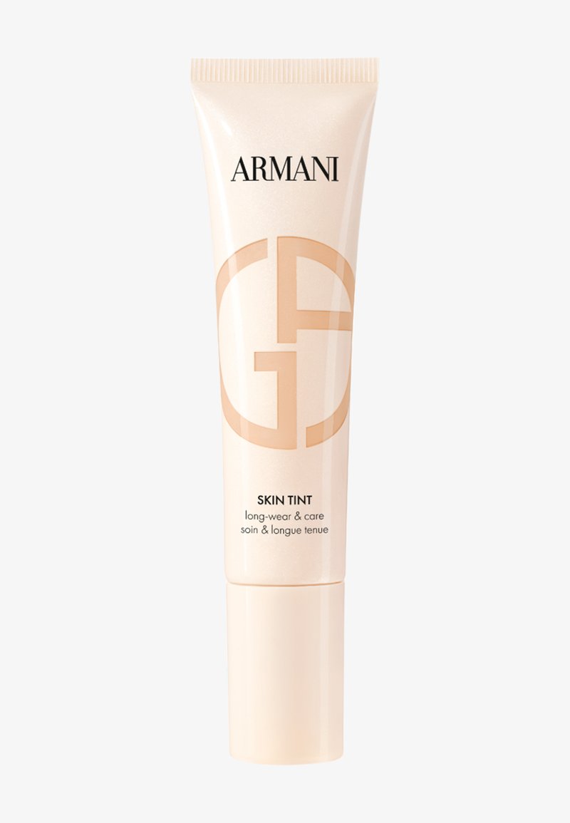 Armani Skin Tint foundation-tube i beige med langvarig holdbarhed og pleje, med Armani-logo og skin tint-mærkat på hvid baggrund.