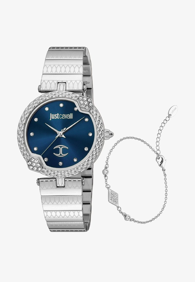 Sidabrinis moteriškas laikrodis su tekstūruota apyranke, mėlynu ciferblatu, kristaliniais žymenimis ir šešiakampiais akcentais. Pridedama atitinkama grandinėlė.
