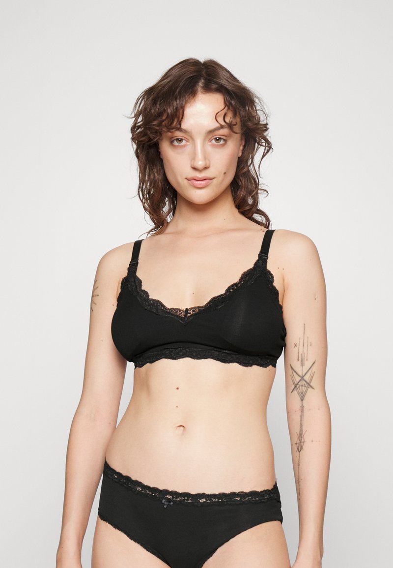 Black lace-trimmed bralette and matching panties. Soft fabric with scalloped edges, adjustable straps, and decorative bow detail on underwear.