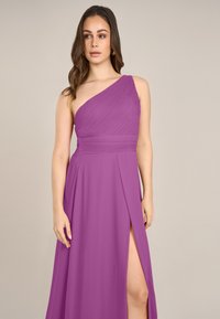 Asymmetrisches One-Shoulder-Kleid in leuchtendem Lila, mit gefälteltem Oberteil, hohem Schlitz und fließendem Stoff. Glatte Textur mit eleganter Drapierung.