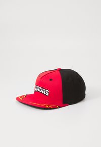 Raudona ir juoda snapback kepurė su išsiuvinėtu "Adidas" logotipu, plokščiu kraštu su geltonais akcentais ir struktūriniu dizainu.