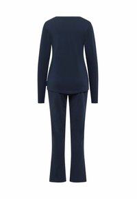 Navyblauwe long-sleeve top gecombineerd met bijpassende flared broek, beide gemaakt van zachte stof, met een eenvoudig ontwerp zonder versieringen.