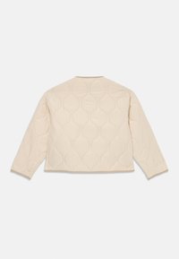 Kremfarget quiltet jakke med lange ermer, rund bølgeformet søm og enkel krage, vist bakfra mot en hvit bakgrunn.