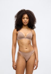 BH- und Slips-Set in hellbraun, aus glattem, elastischem Stoff. Der BH hat einen tiefen Ausschnitt und dünne verstellbare Träger.