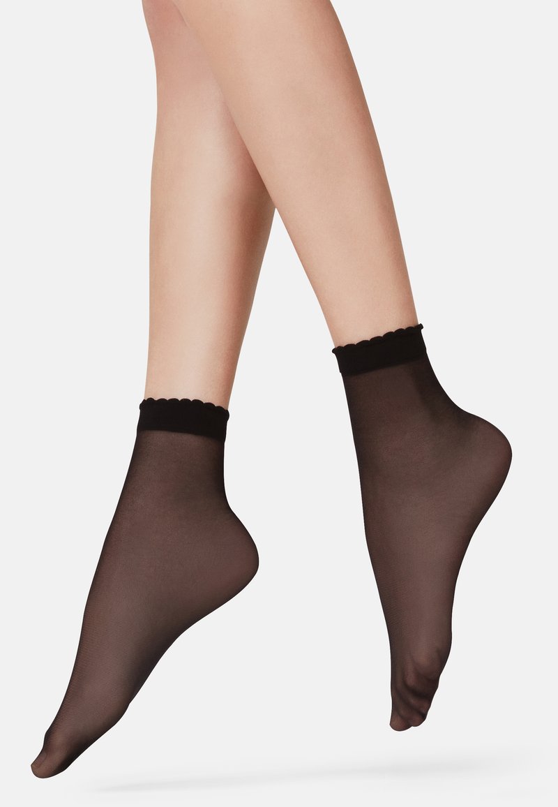 Medias invisibles negras de material ligero con un borde superior en forma de onda, exhibidas sobre un fondo blanco.