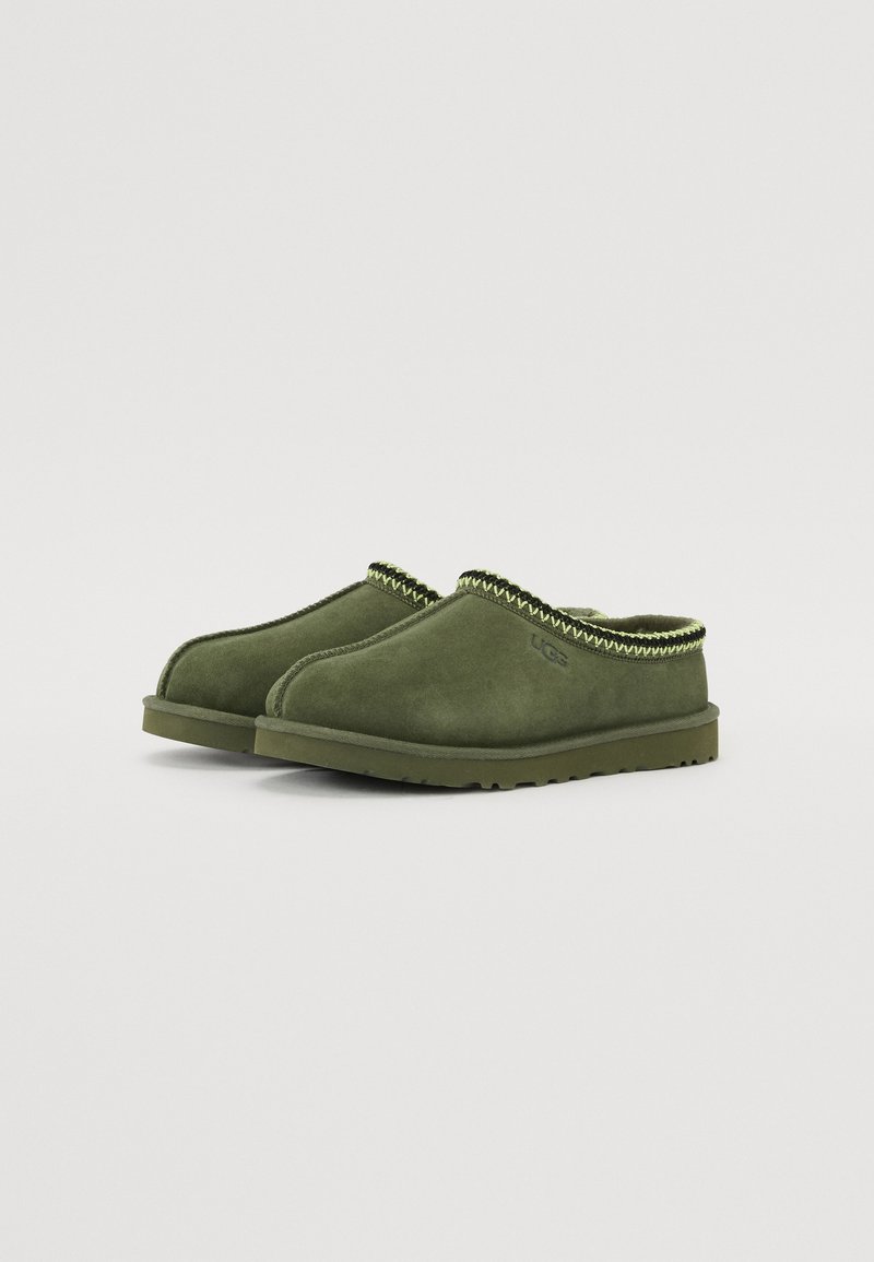Groene suède klompen met een laag profiel, voorzien van een gegarneerde groene en gele gevlochten rand en een rubberen buitenzool voor grip.